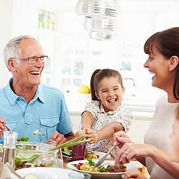 family smiling at dining table