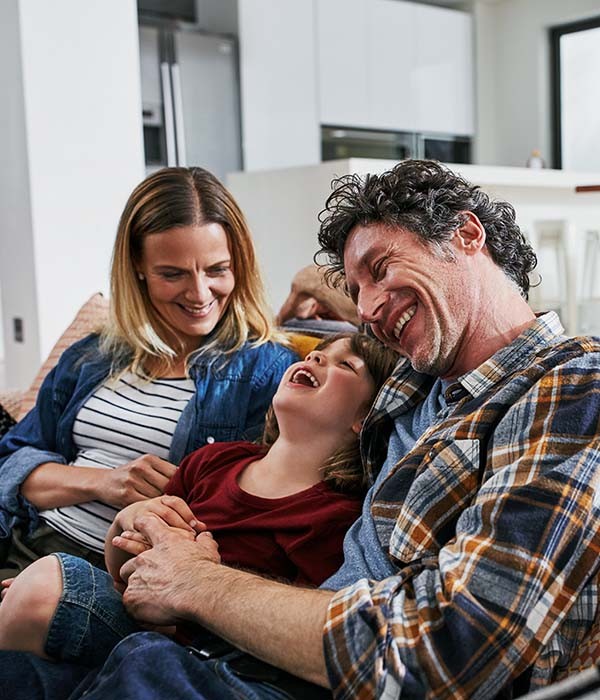 Happy family laughing together on a couch in a cozy room in Hunterdon County, NJ
