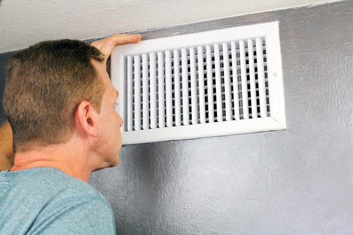 A Man inspecting a ceiling air vent in Hunterdon County, NJ